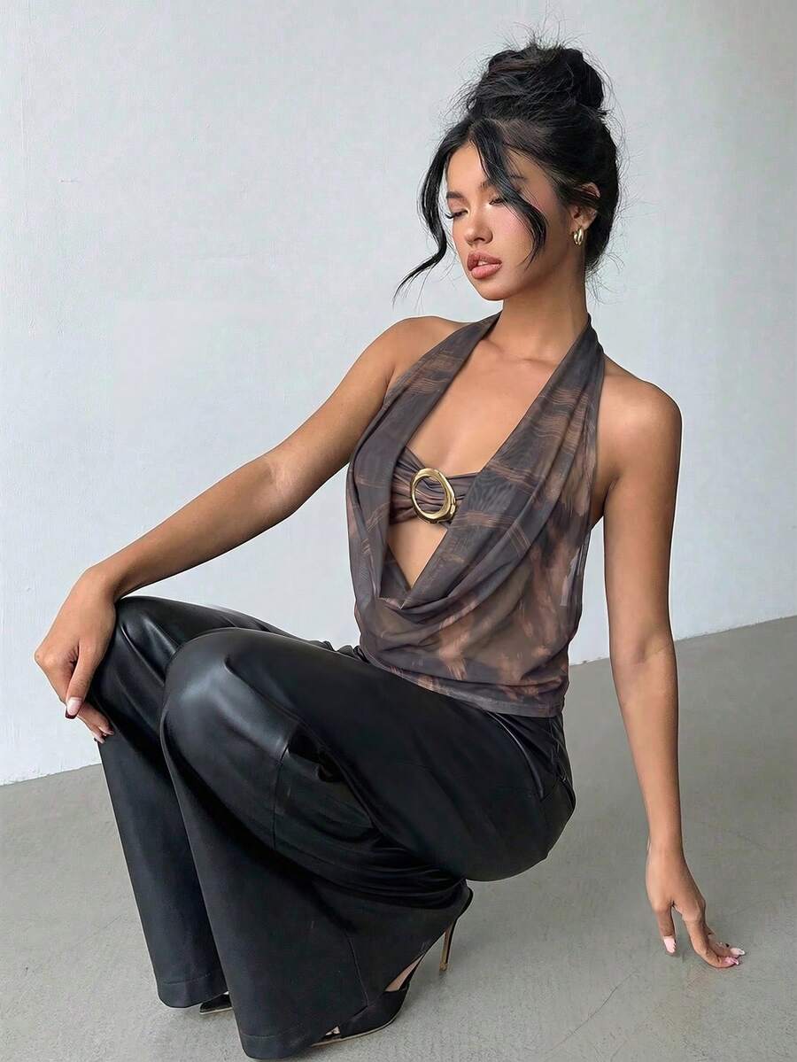 Brown and white polka dot semi-sheer halter camisole top with a plunging neckline, backless design, draped front, and metallic studded embellishments.