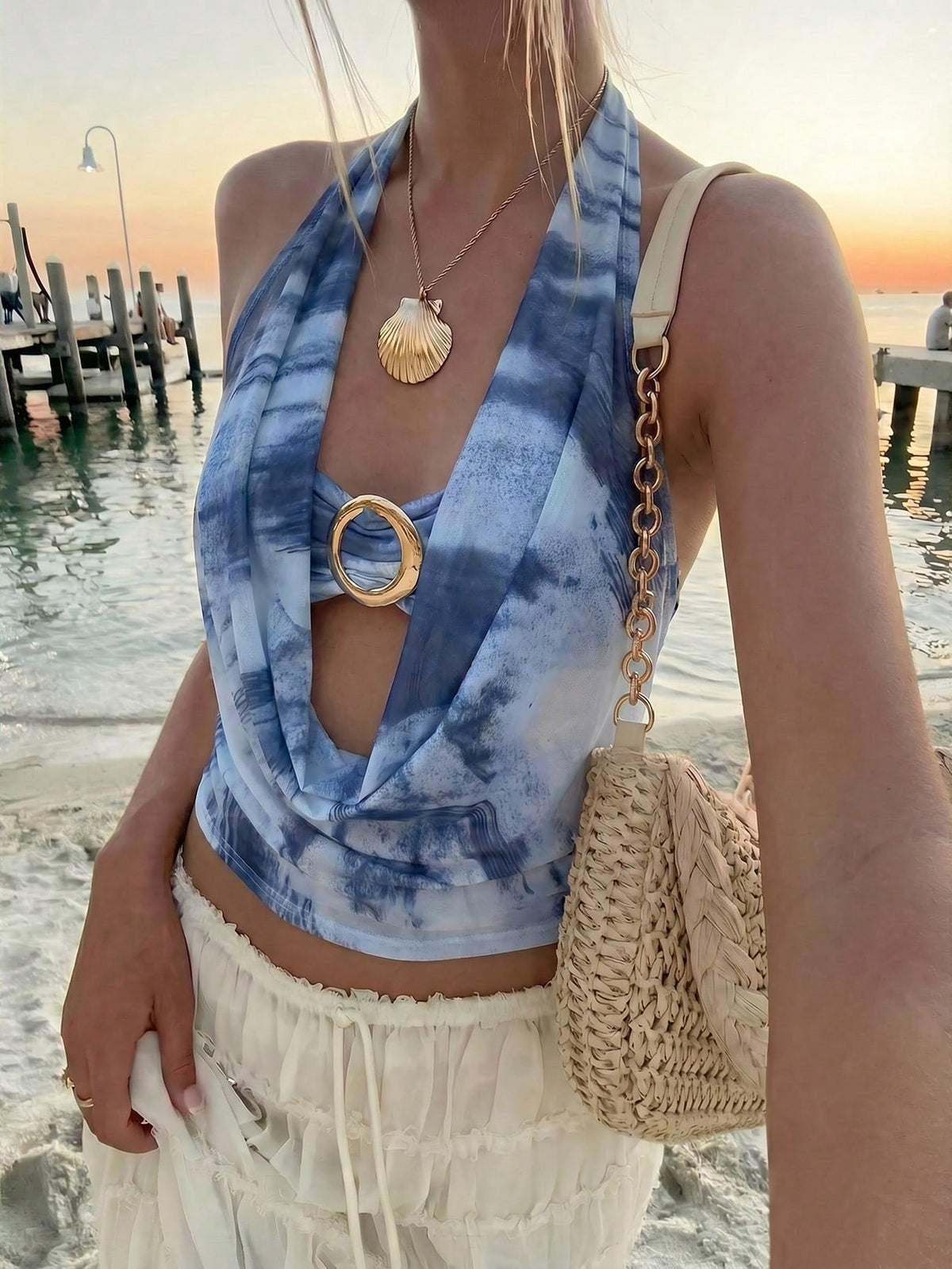 Brown and white polka dot semi-sheer halter camisole top with a plunging neckline, backless design, draped front, and metallic studded embellishments.