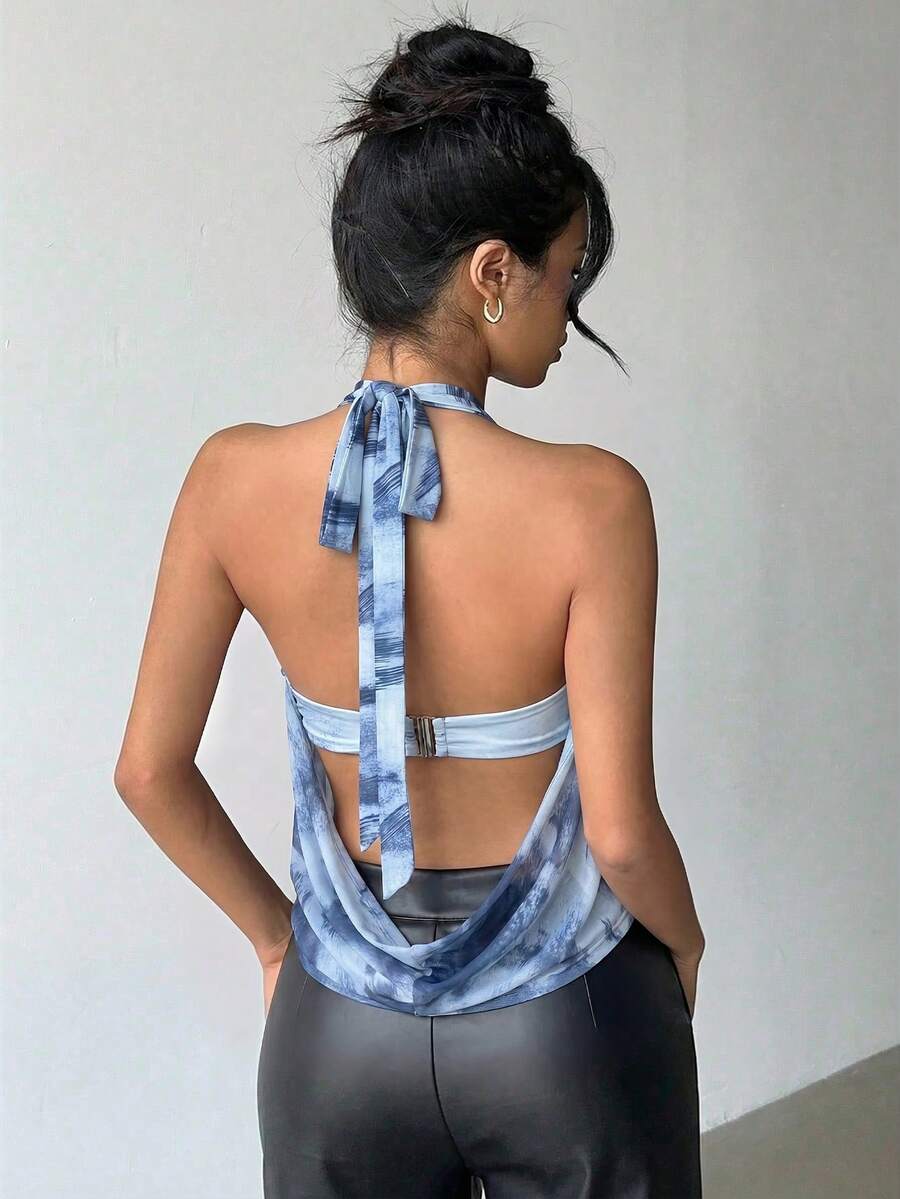 Brown and white polka dot semi-sheer halter camisole top with a plunging neckline, backless design, draped front, and metallic studded embellishments.