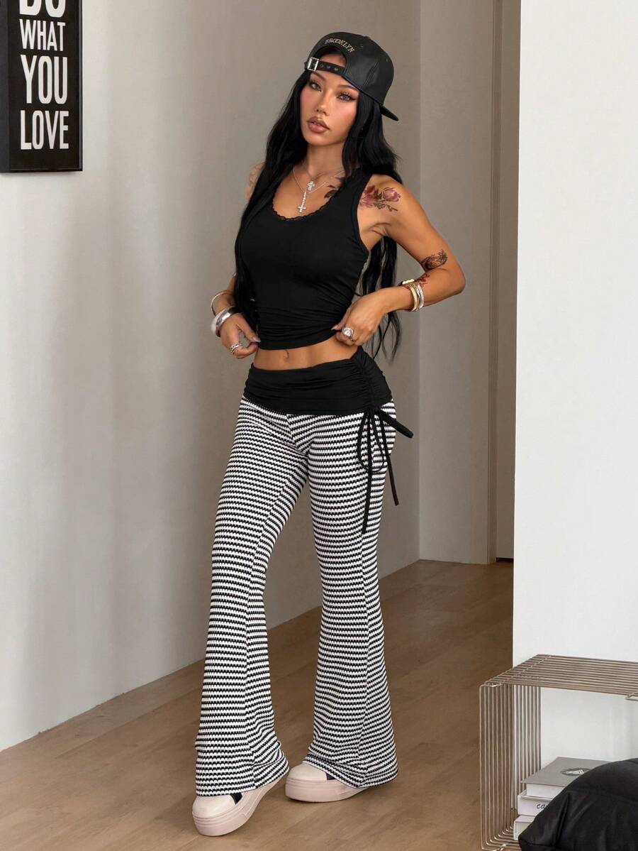 Women's black and white polka dot flare leg pants with side drawstring and ruched details
