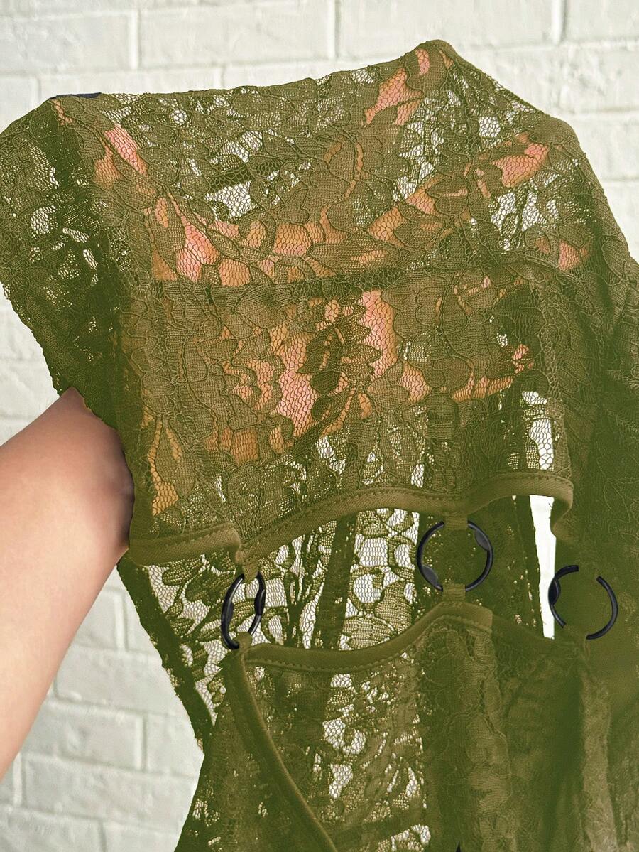 Women's black slim fit semi-sheer blouse featuring contrast lace detailing, a deep V hollow design with ring accent, asymmetrical hem, and cap sleeves.