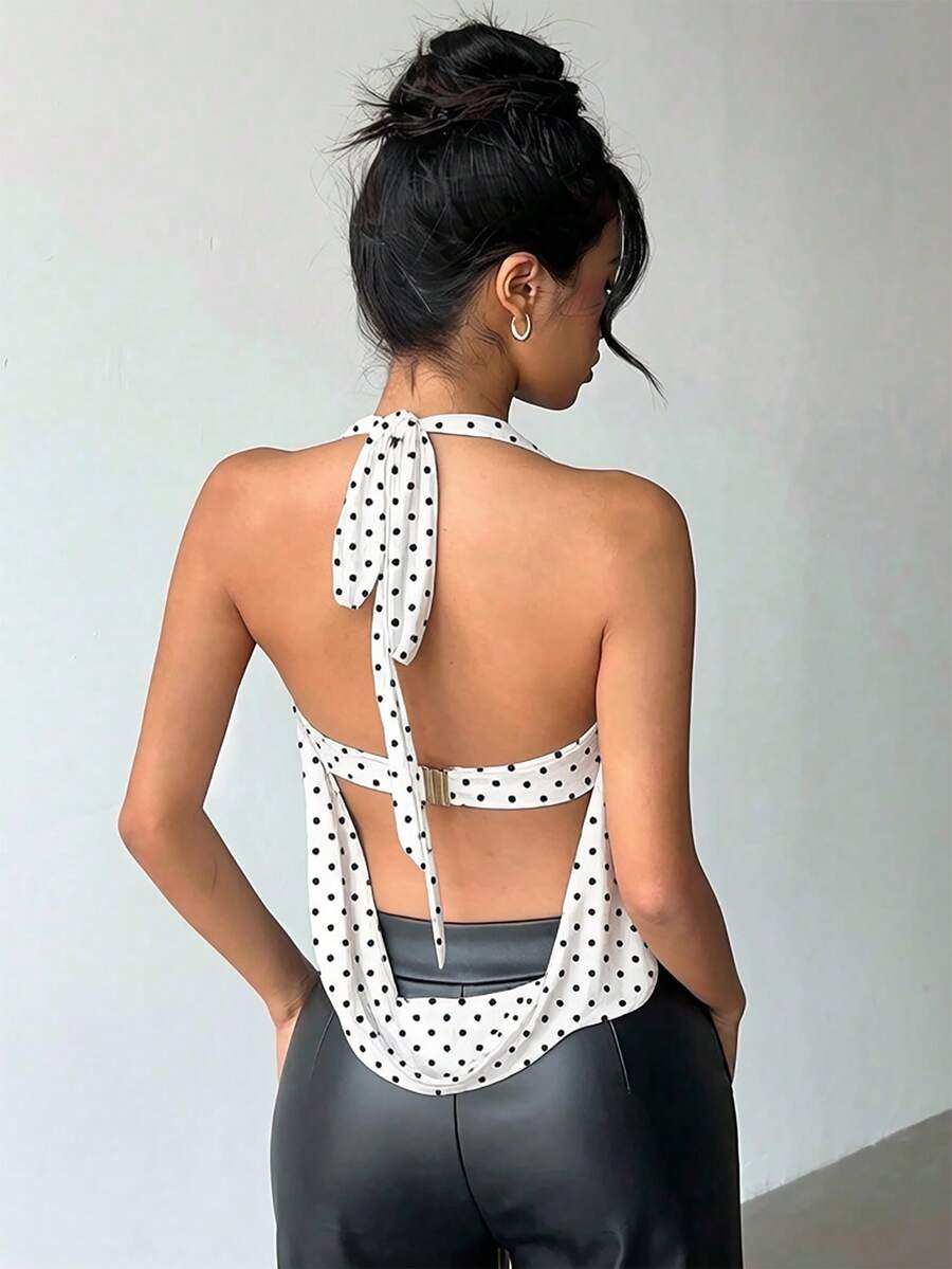 Brown and white polka dot semi-sheer halter camisole top with a plunging neckline, backless design, draped front, and metallic studded embellishments.