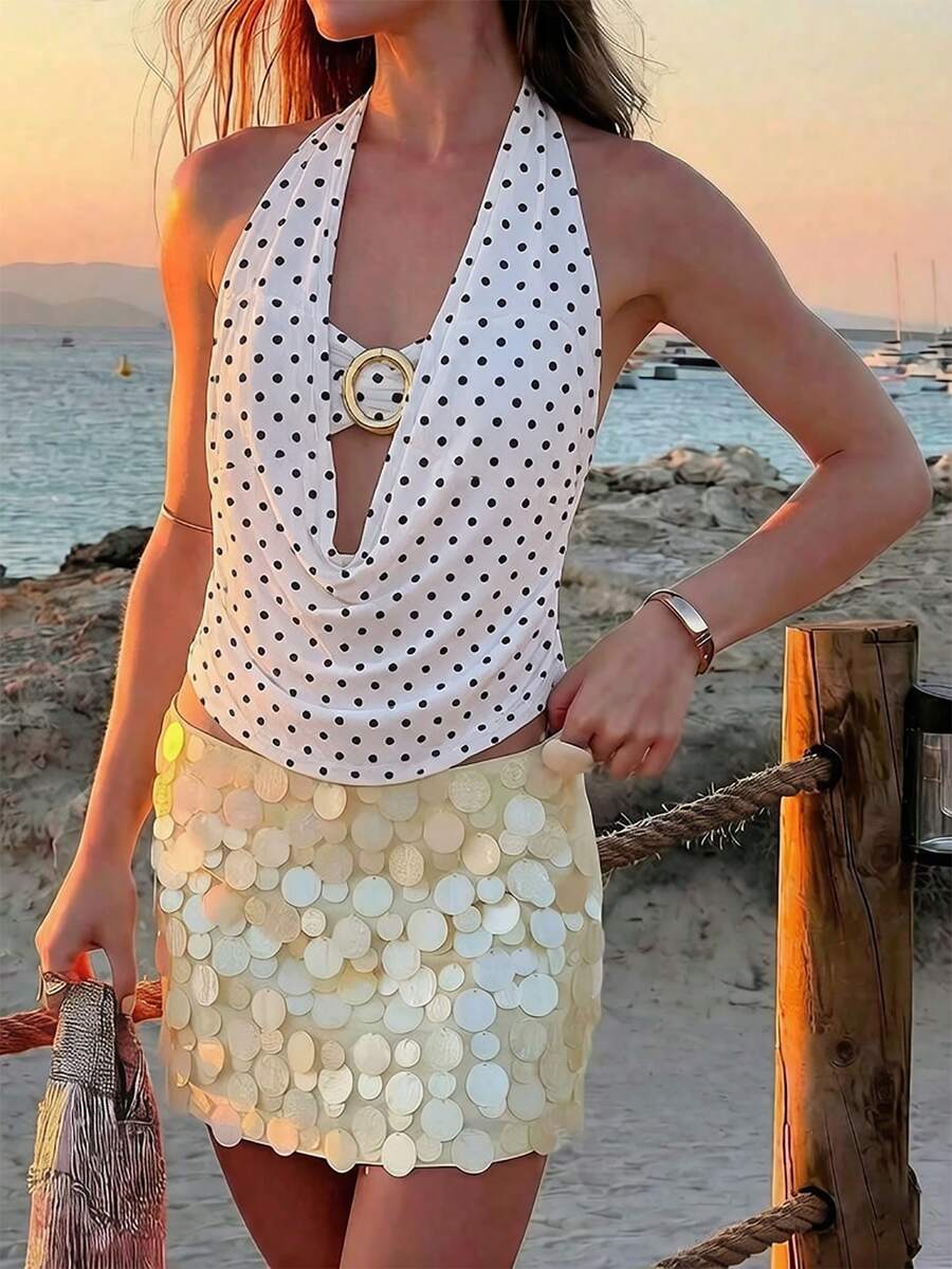 Brown and white polka dot semi-sheer halter camisole top with a plunging neckline, backless design, draped front, and metallic studded embellishments.