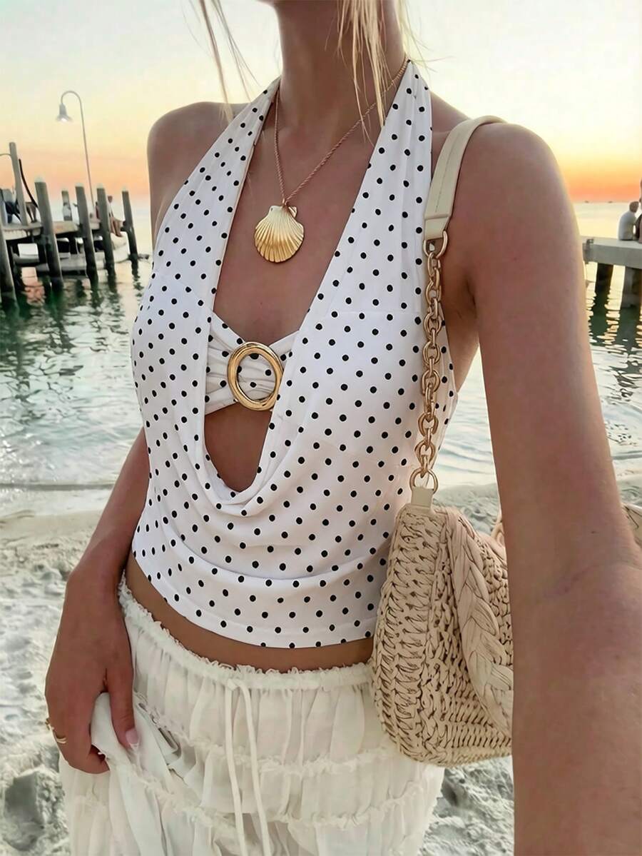 Brown and white polka dot semi-sheer halter camisole top with a plunging neckline, backless design, draped front, and metallic studded embellishments.