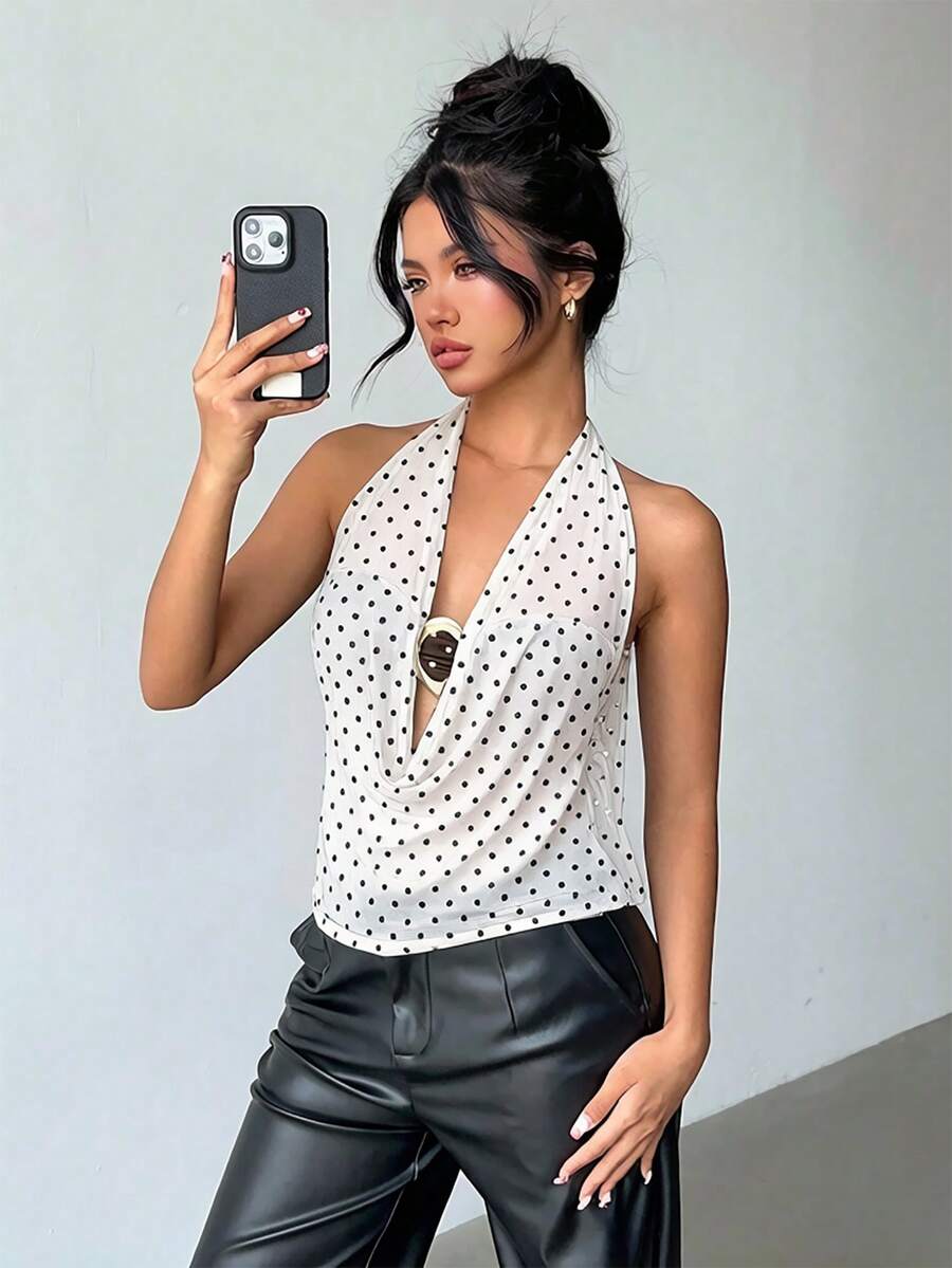 Brown and white polka dot semi-sheer halter camisole top with a plunging neckline, backless design, draped front, and metallic studded embellishments.