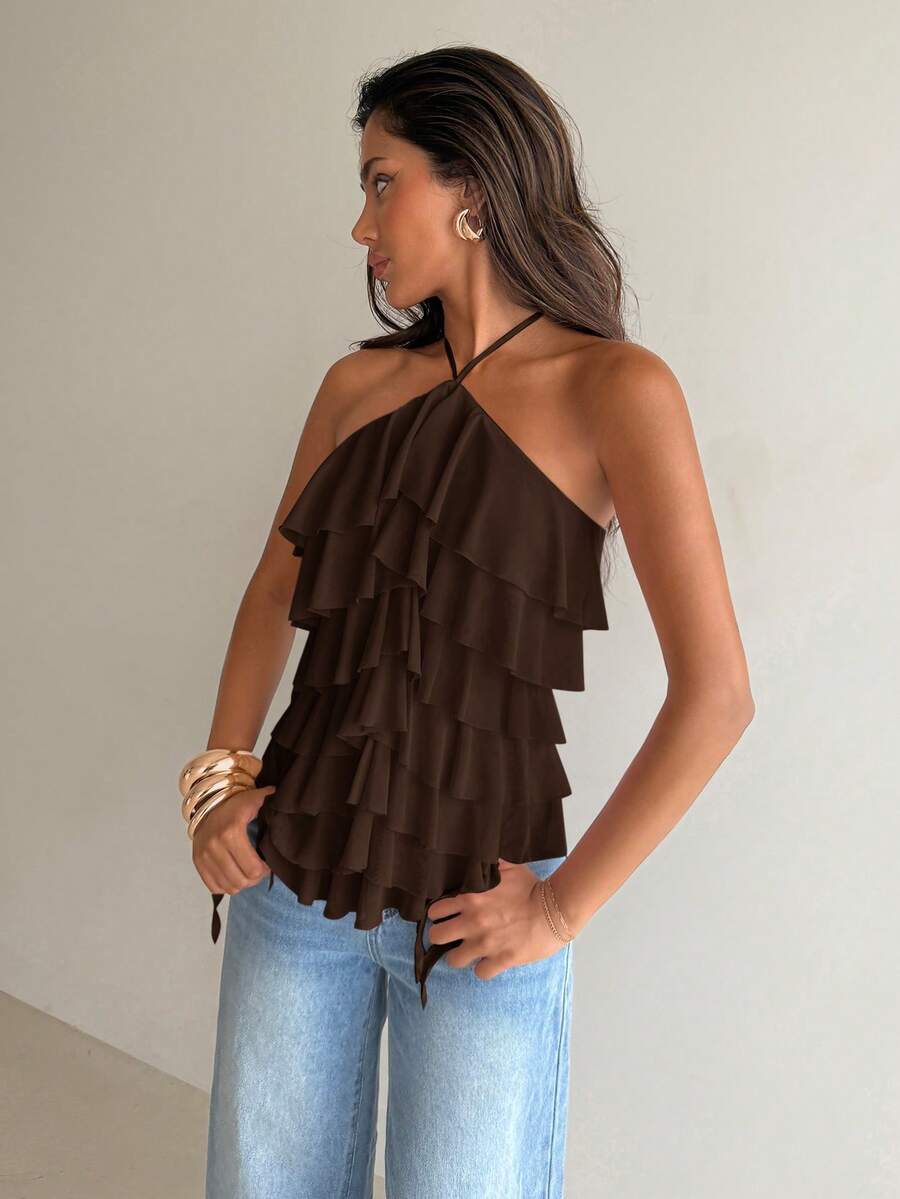 Women's sleeveless halter neck top featuring tiered ruffle layers, a backless cut, and an asymmetrical hem.
