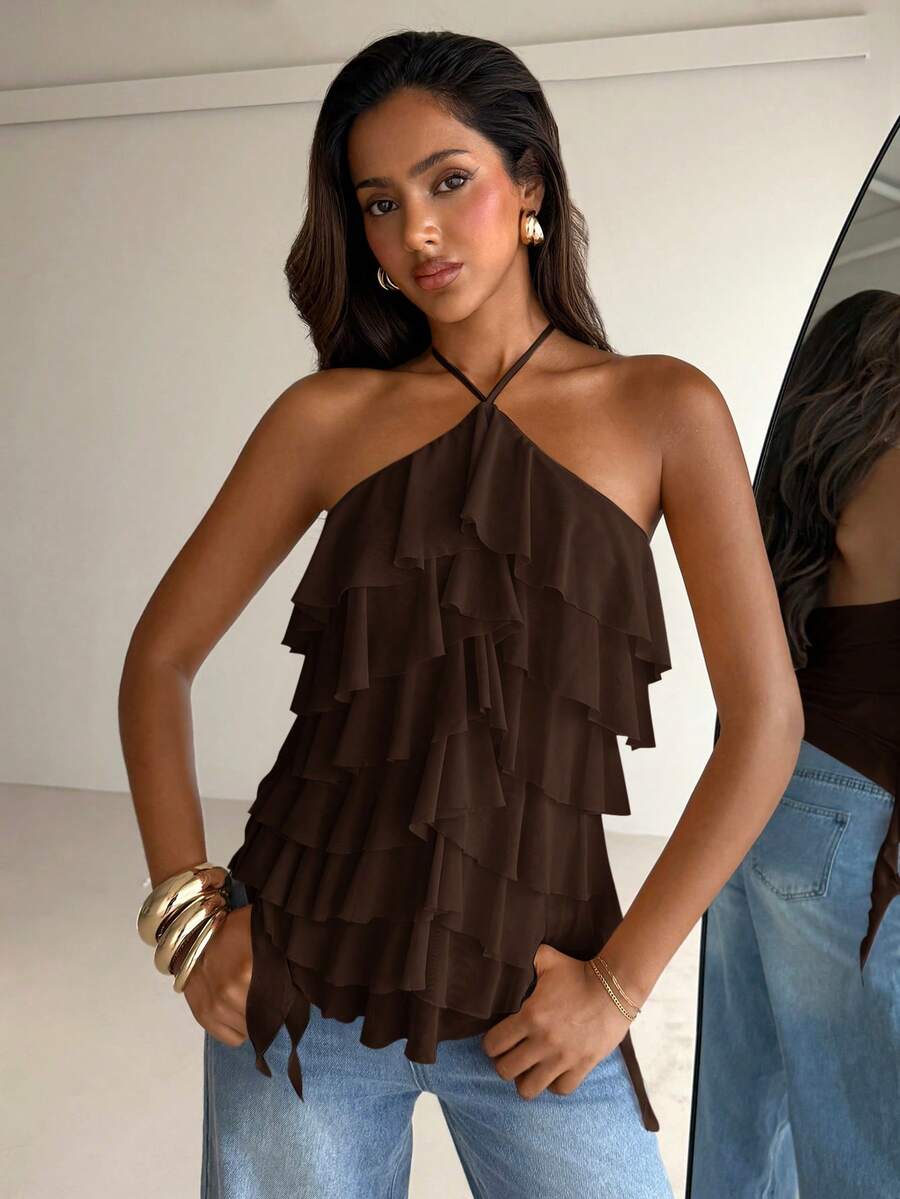 Women's sleeveless halter neck top featuring tiered ruffle layers, a backless cut, and an asymmetrical hem.