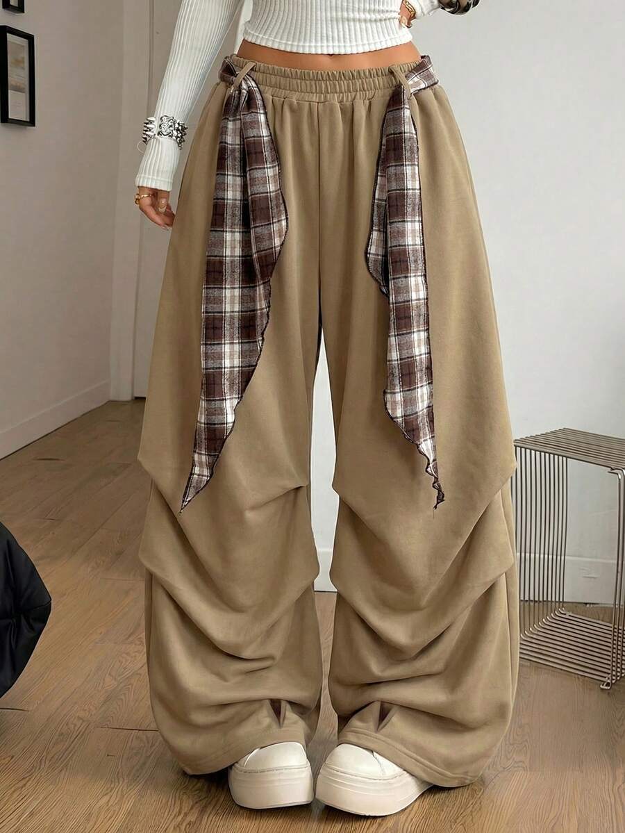 Loose-fitting black baggy parachute pants featuring an elastic drawstring waistband and wide-leg cut made from cotton blend fabric.