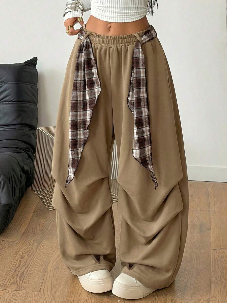 Loose-fitting black baggy parachute pants featuring an elastic drawstring waistband and wide-leg cut made from cotton blend fabric.