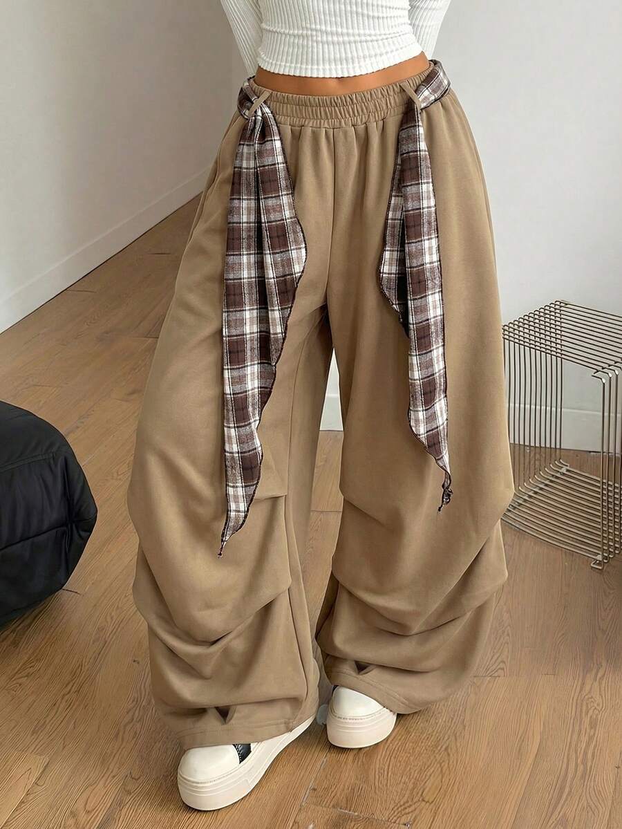Loose-fitting black baggy parachute pants featuring an elastic drawstring waistband and wide-leg cut made from cotton blend fabric.