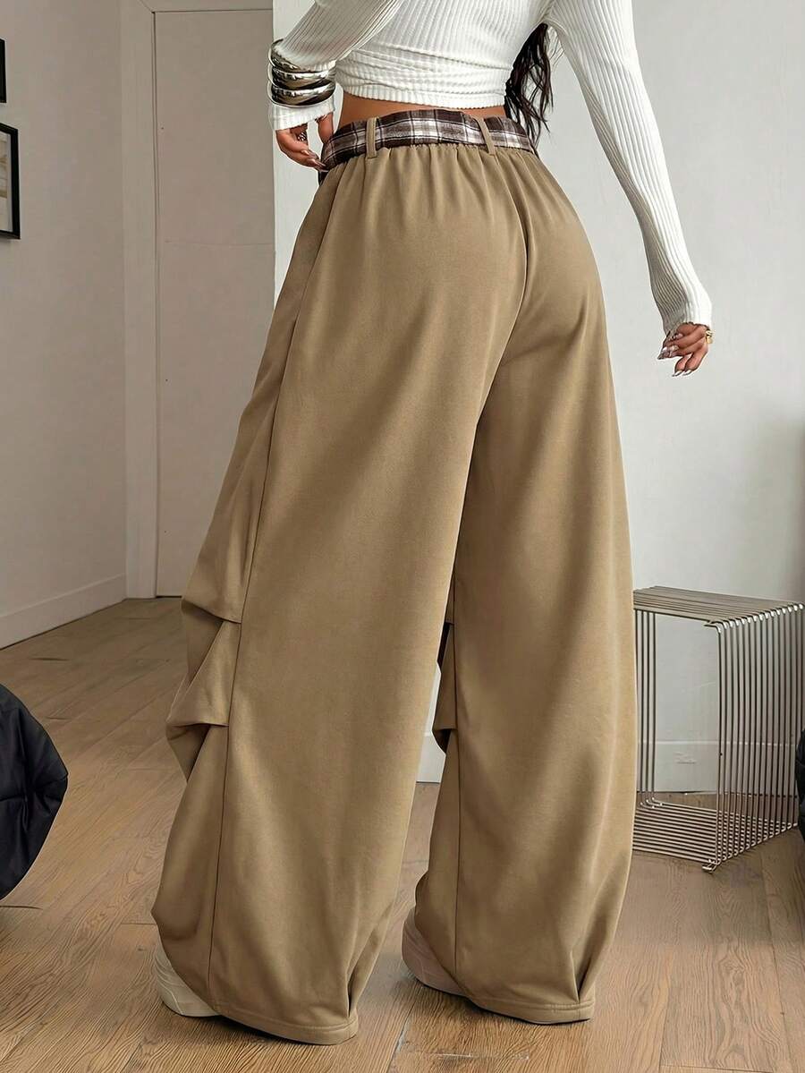 Loose-fitting black baggy parachute pants featuring an elastic drawstring waistband and wide-leg cut made from cotton blend fabric.