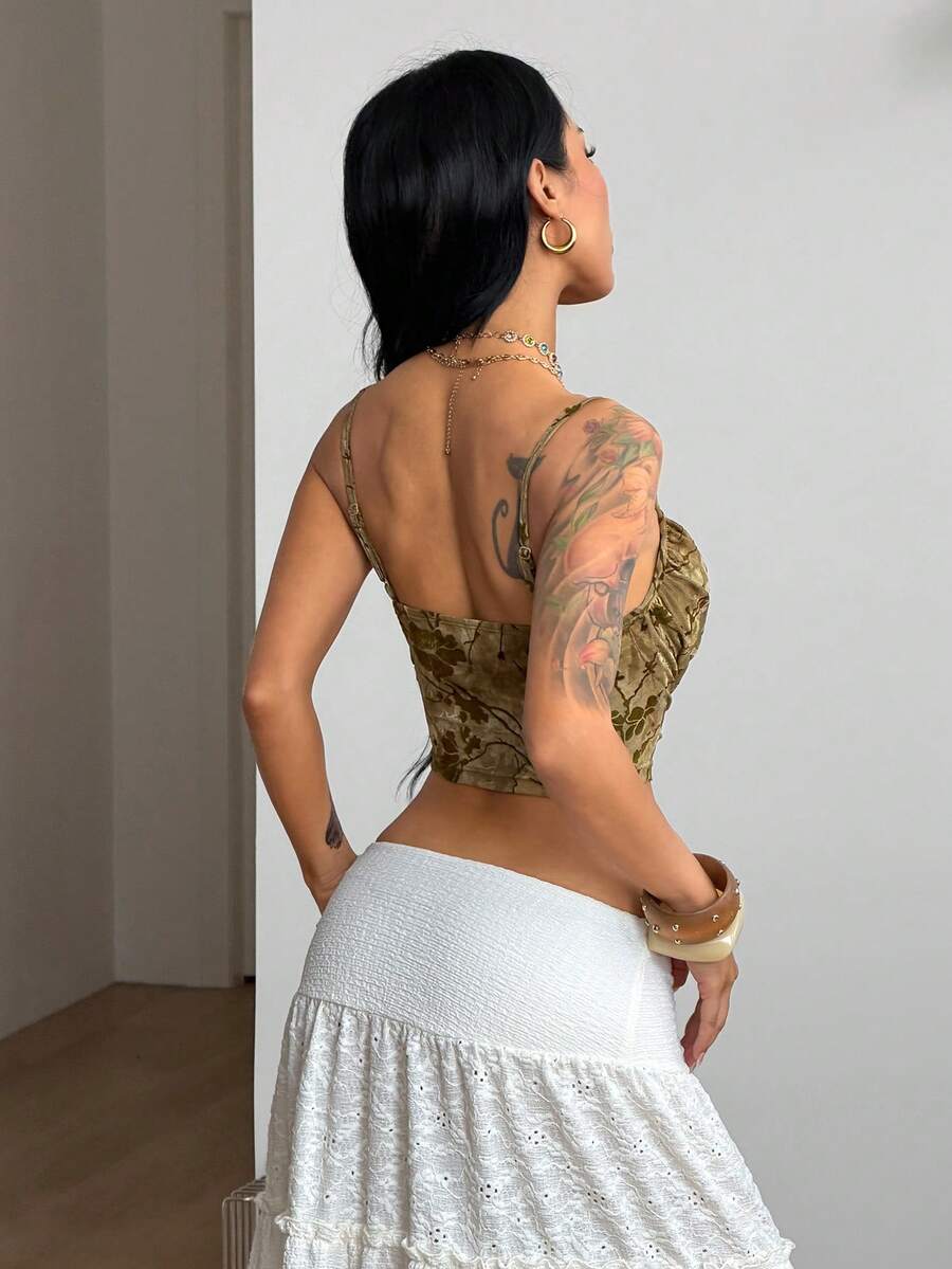 Women's black knit slim fit camisole top featuring contrast lace detailing, a backless design, ruched accent, and thin spaghetti straps.