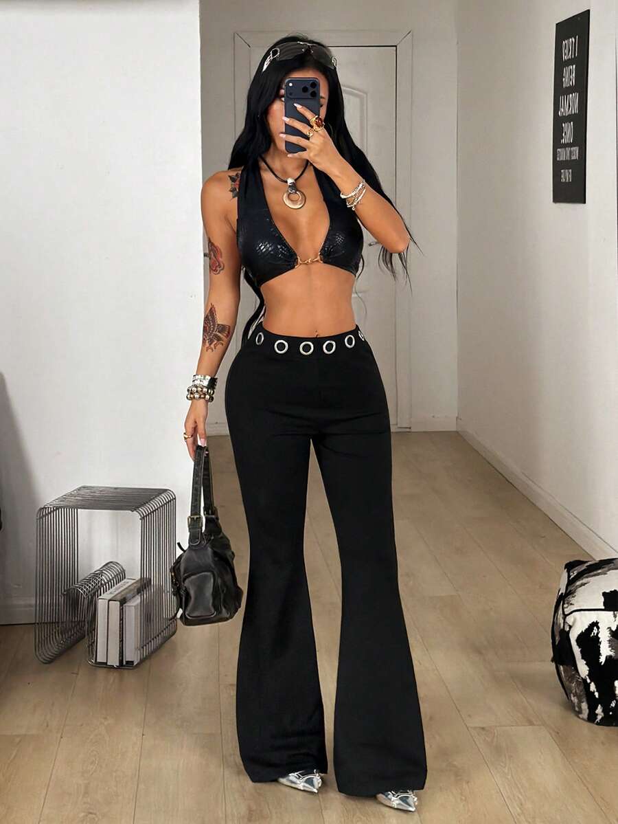 Women's black stretchy mid rise flare pants with grommet eyelet detailing along the legs.