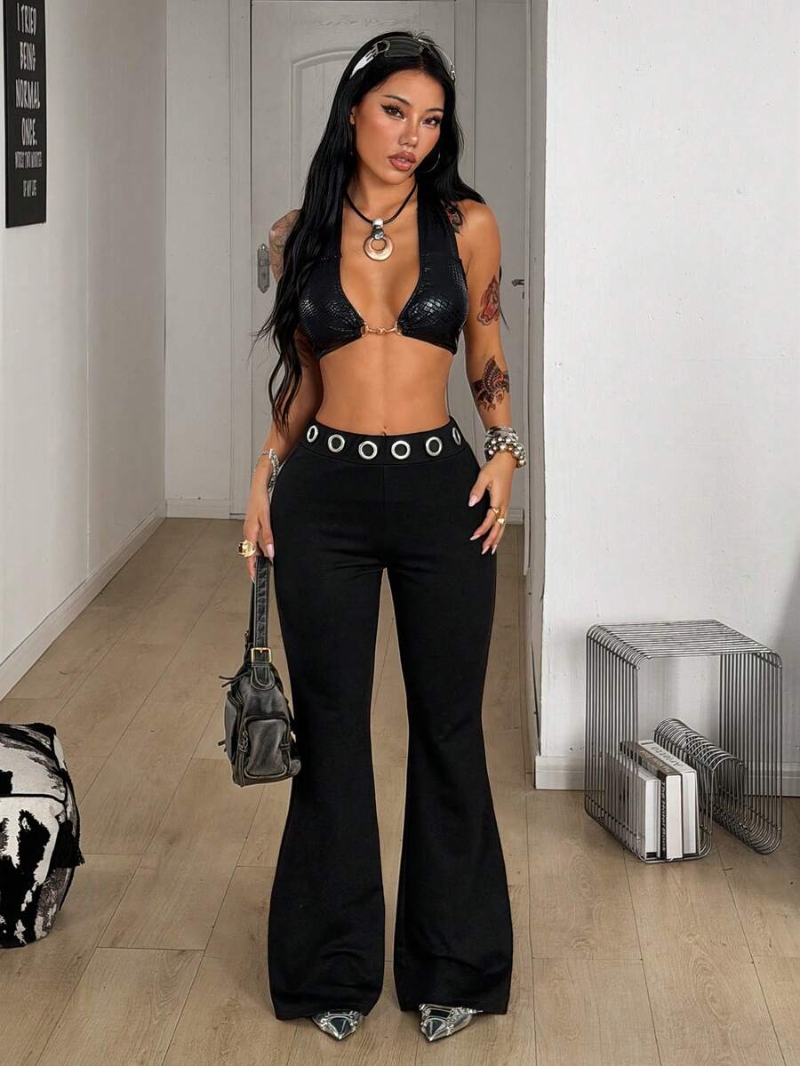Women's black stretchy mid rise flare pants with grommet eyelet detailing along the legs.