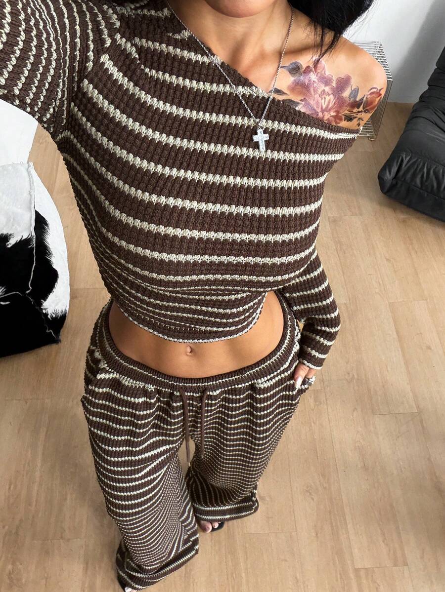 Women's two-piece striped knit tracksuit set featuring a brown asymmetrical neckline long sleeve crop top and matching high-waisted wide leg sweatpants.