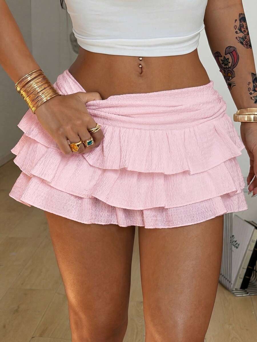 Women's white low waist tiered mini skirt featuring ruched detailing and a slight-stretch knitted fabric.