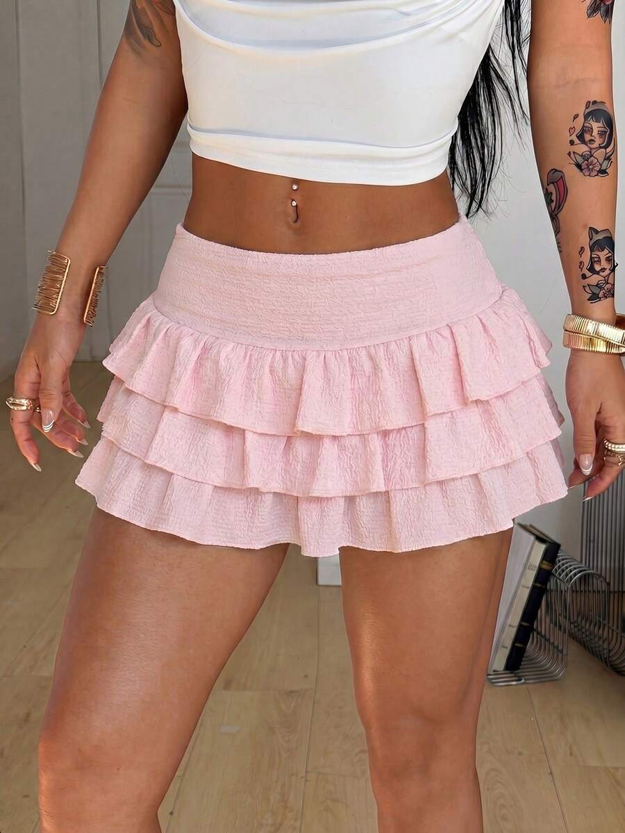 Women's white low waist tiered mini skirt featuring ruched detailing and a slight-stretch knitted fabric.