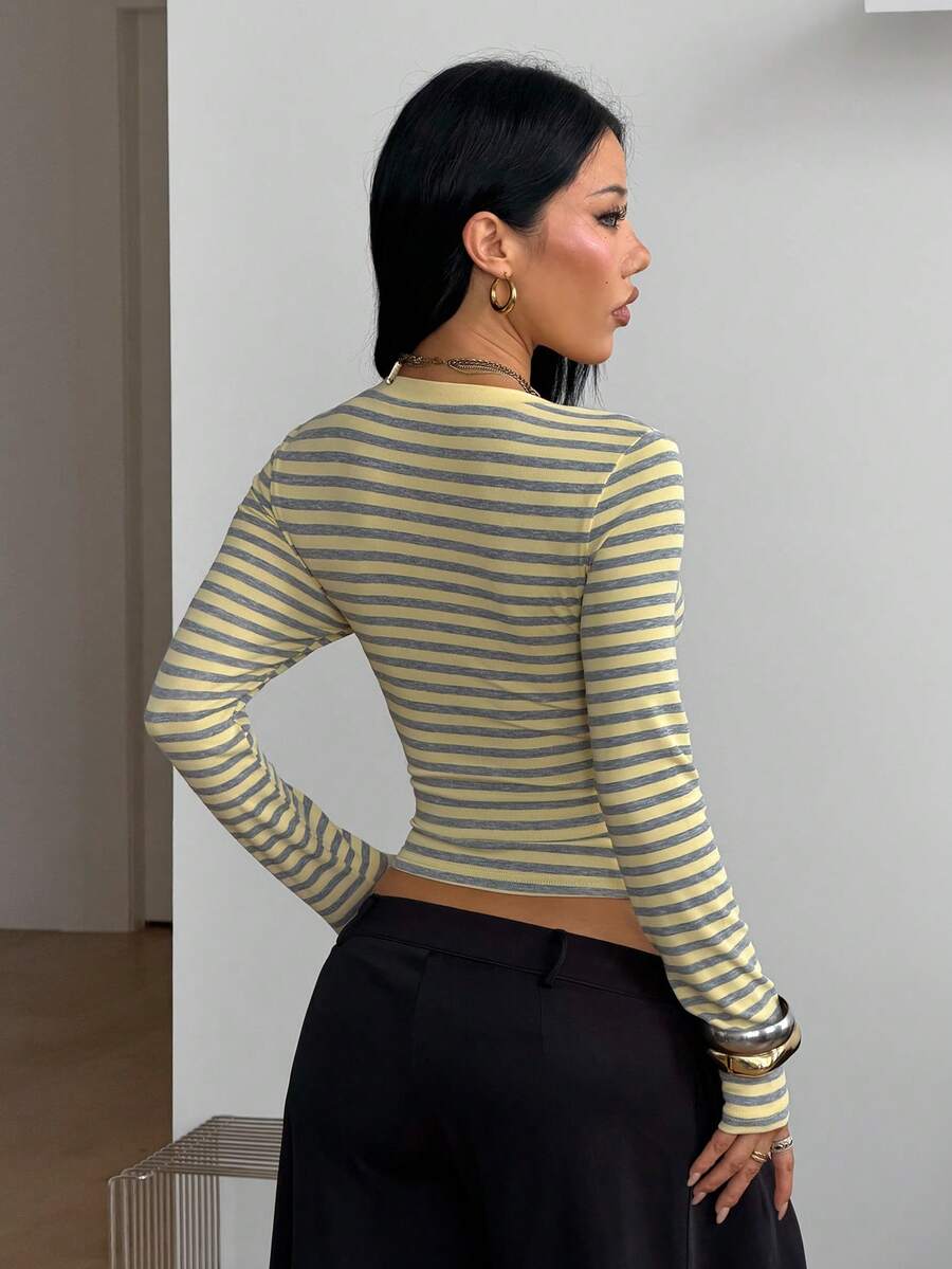 Women's fitted long sleeve rib-knit top featuring a deep V-neckline with delicate contrast lace detailing.