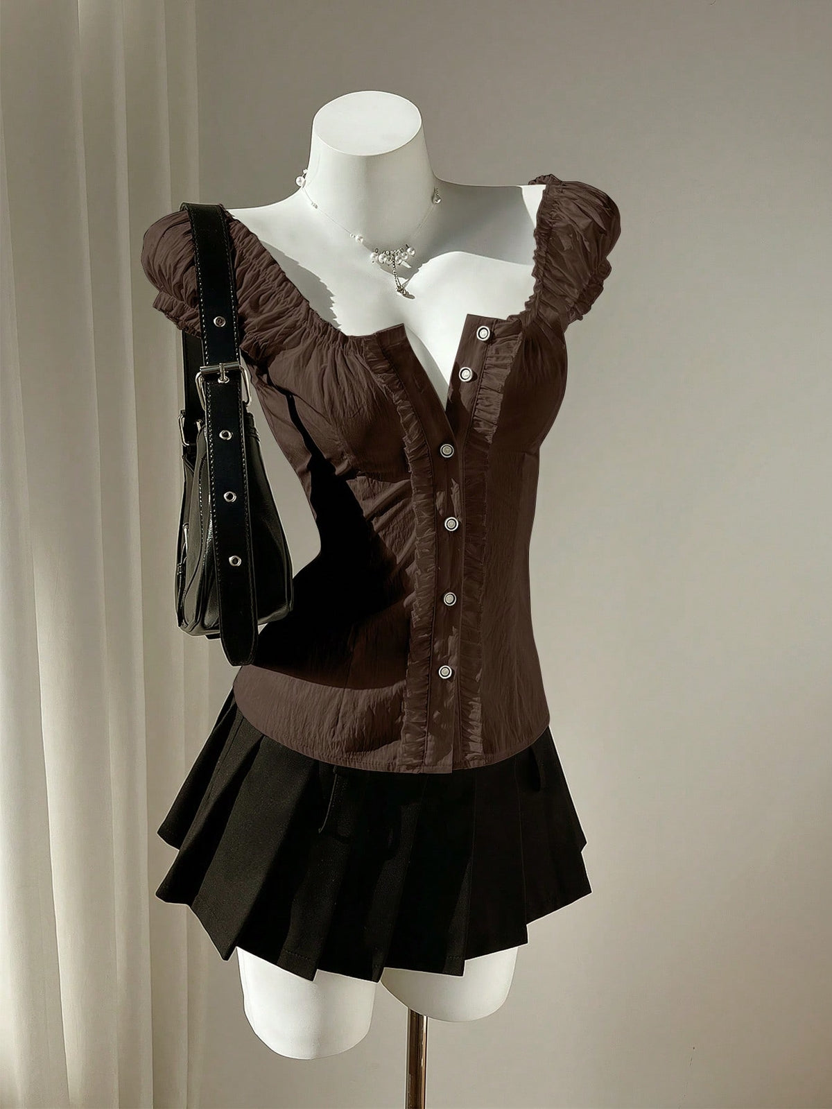Women's black off-shoulder cap sleeve blouse with ruffled detailing and a tie-back design.