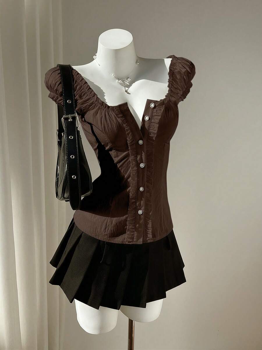 Women's black off-shoulder cap sleeve blouse with ruffled detailing and a tie-back design.