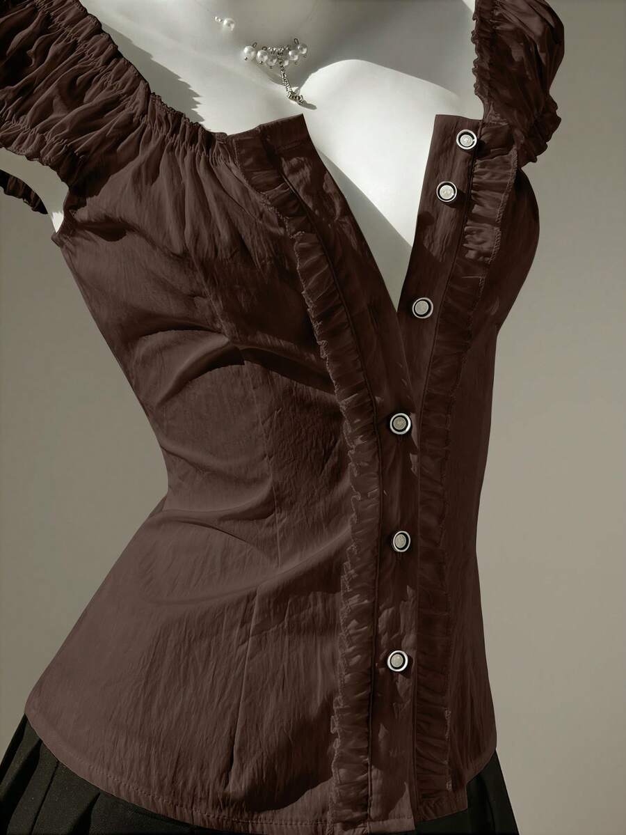 Women's black off-shoulder cap sleeve blouse with ruffled detailing and a tie-back design.