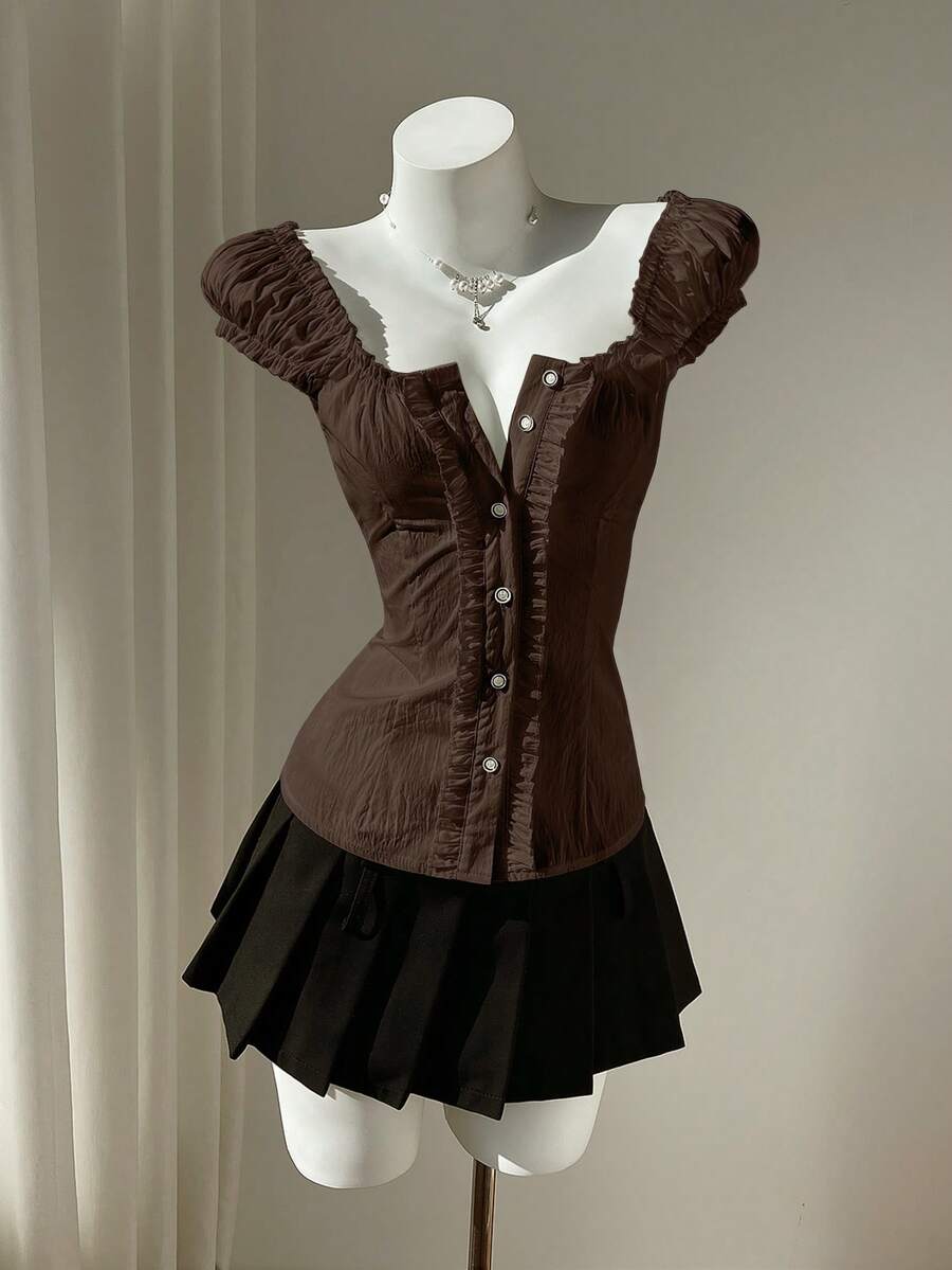 Women's black off-shoulder cap sleeve blouse with ruffled detailing and a tie-back design.