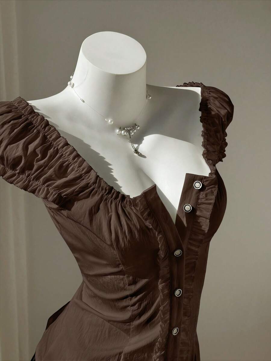 Women's black off-shoulder cap sleeve blouse with ruffled detailing and a tie-back design.