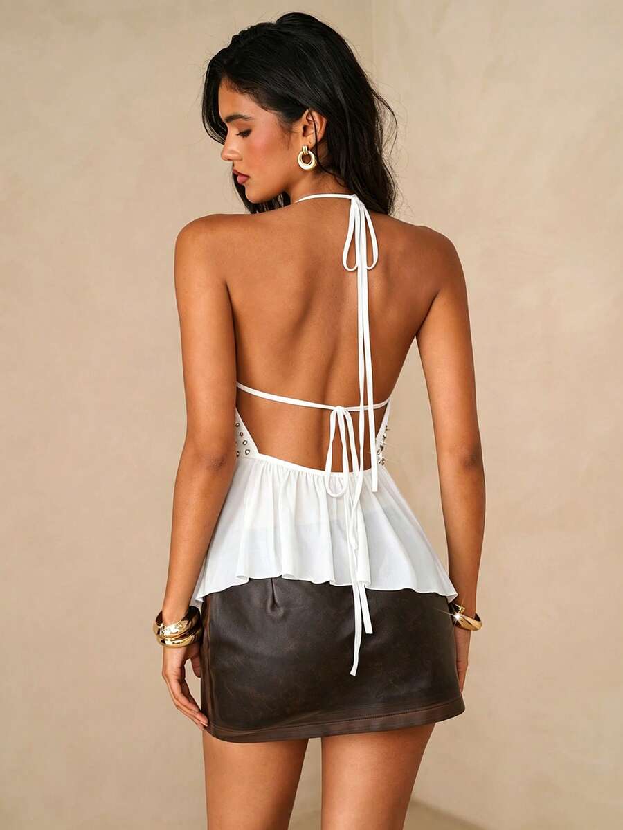 Women's black studded halter cami top with spaghetti straps, tie-back backless design, and asymmetrical hem