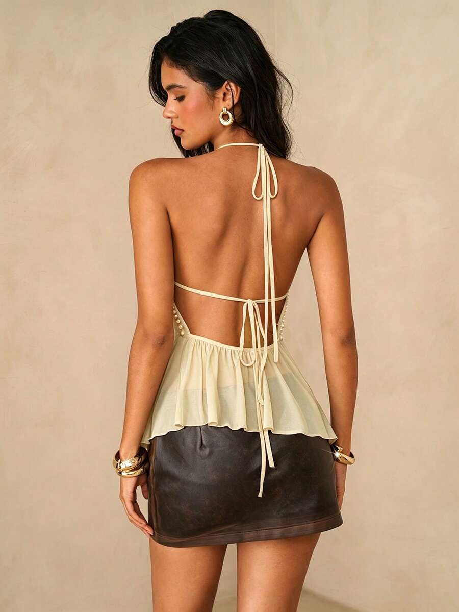Women's black studded halter cami top with spaghetti straps, tie-back backless design, and asymmetrical hem