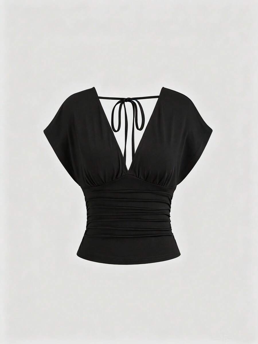 Women's black knitted t-shirt featuring a reversible deep v-neckline, batwing cap sleeves, ruched detailing, and a slim fit waist.
