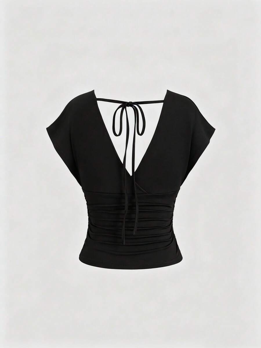 Women's black knitted t-shirt featuring a reversible deep v-neckline, batwing cap sleeves, ruched detailing, and a slim fit waist.