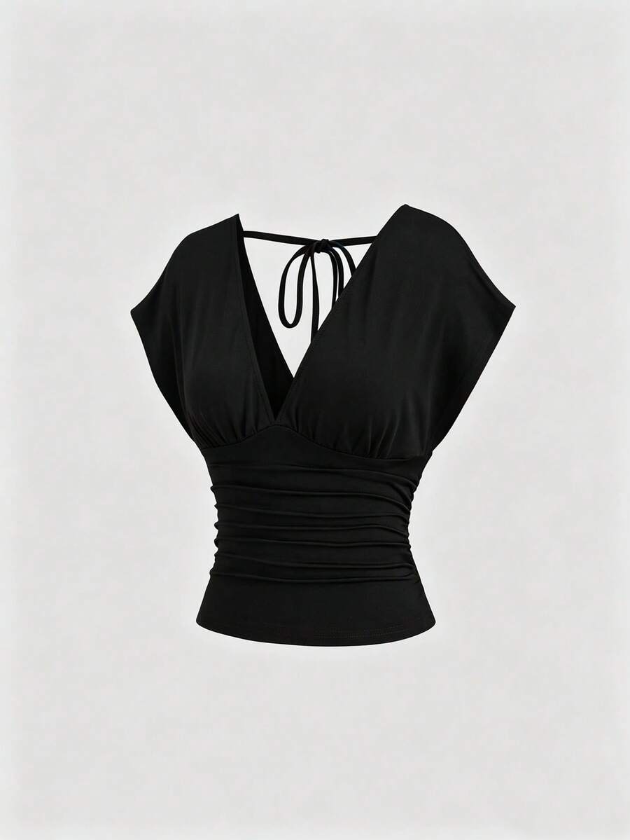 Women's black knitted t-shirt featuring a reversible deep v-neckline, batwing cap sleeves, ruched detailing, and a slim fit waist.
