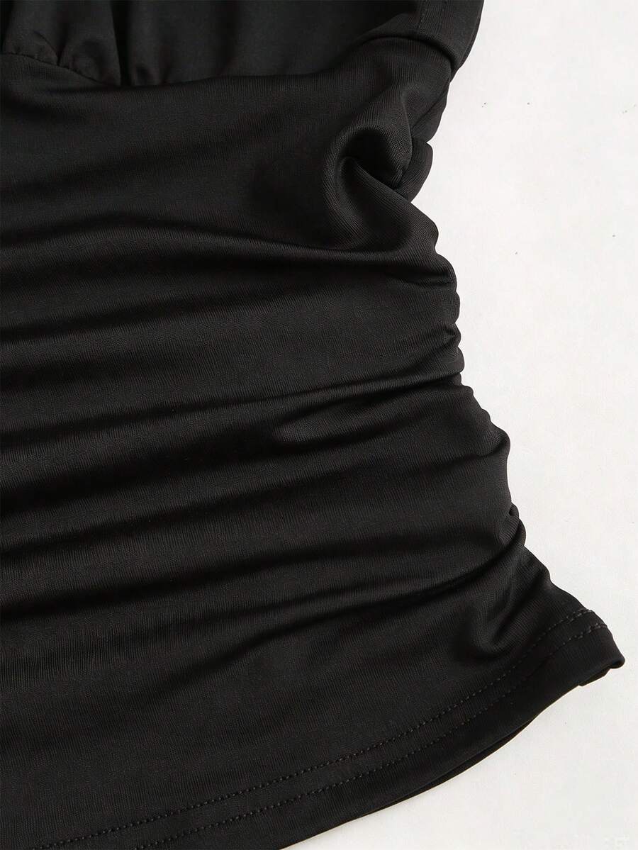 Women's black knitted t-shirt featuring a reversible deep v-neckline, batwing cap sleeves, ruched detailing, and a slim fit waist.