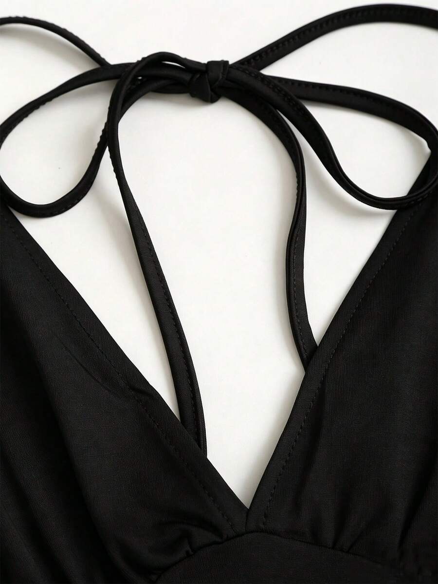 Women's black knitted t-shirt featuring a reversible deep v-neckline, batwing cap sleeves, ruched detailing, and a slim fit waist.