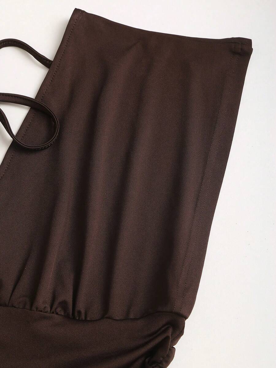 Women's black knitted t-shirt featuring a reversible deep v-neckline, batwing cap sleeves, ruched detailing, and a slim fit waist.