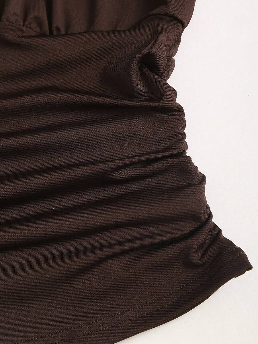 Women's black knitted t-shirt featuring a reversible deep v-neckline, batwing cap sleeves, ruched detailing, and a slim fit waist.