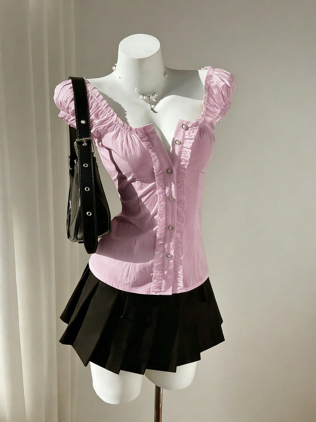 Women's black off-shoulder cap sleeve blouse with ruffled detailing and a tie-back design.