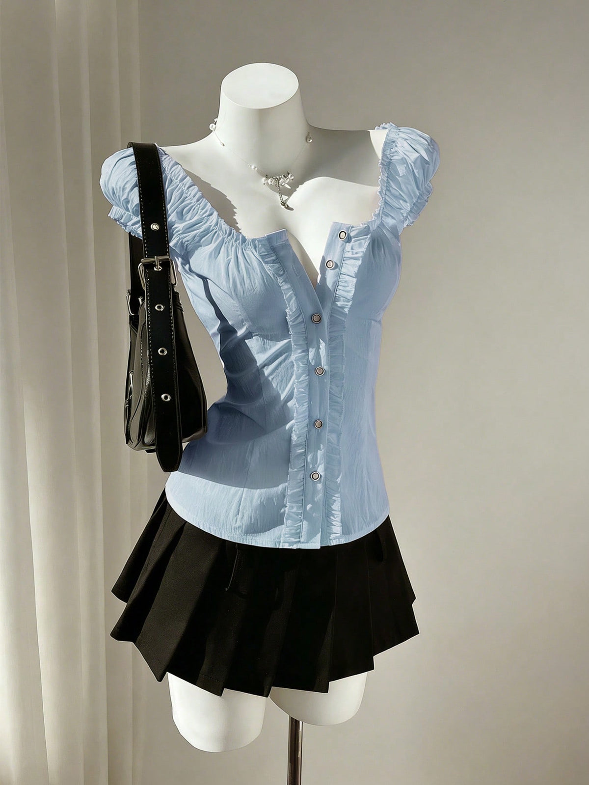 Women's black off-shoulder cap sleeve blouse with ruffled detailing and a tie-back design.