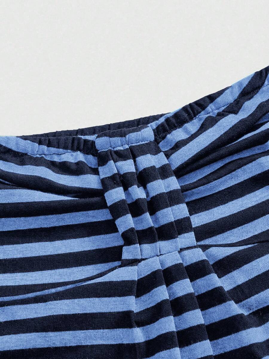 Women's striped strapless tube top featuring ruched detailing, flared hem, and stretchy knit fabric.