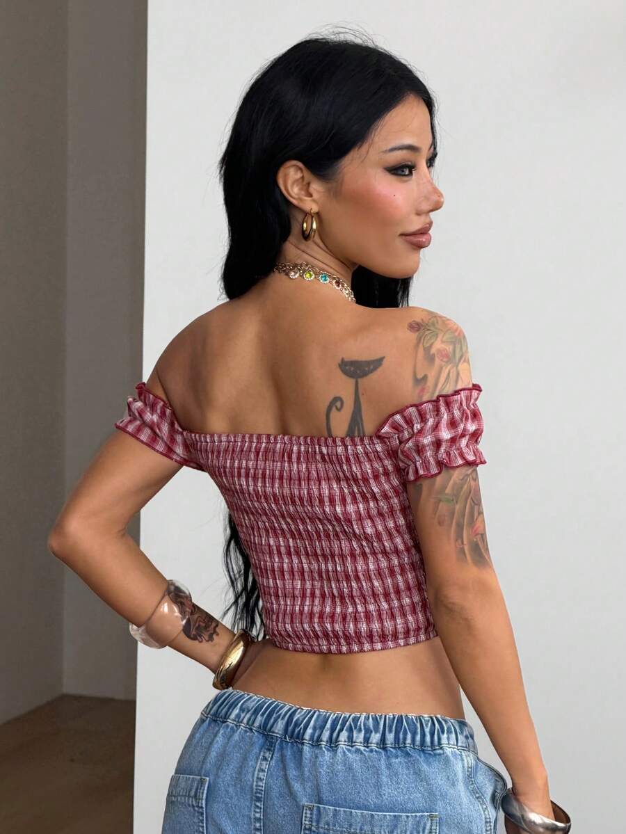 Red and white plaid off-the-shoulder crop top for women featuring puff cap sleeves, frill trim, and a fitted hem.