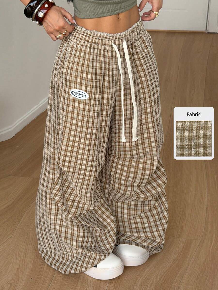 Women's black and white striped wide leg pants featuring an elastic drawstring waistband, side pockets, and a loose straight leg fit.