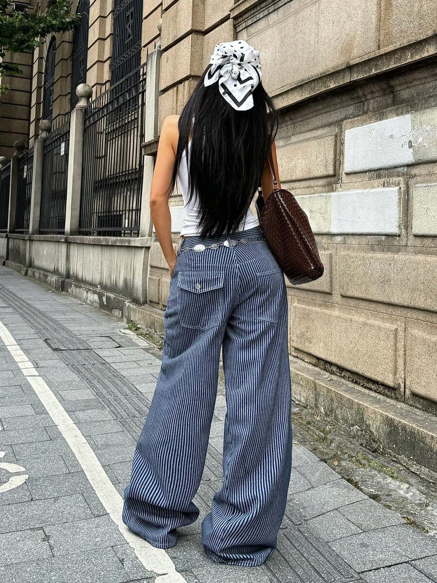 Front view of women's loose wide leg denim jeans featuring a mid waist, classic front pockets, and a zipper fly closure.