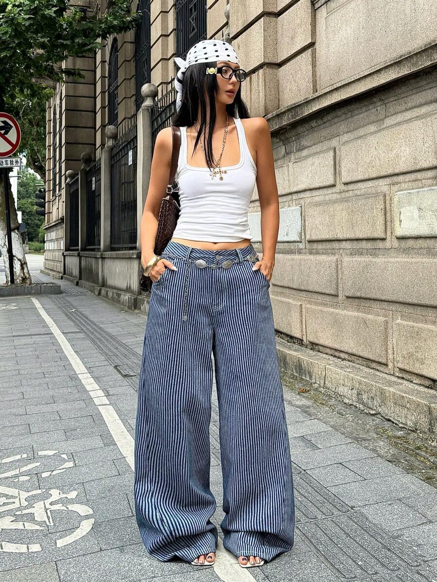 Front view of women's loose wide leg denim jeans featuring a mid waist, classic front pockets, and a zipper fly closure.