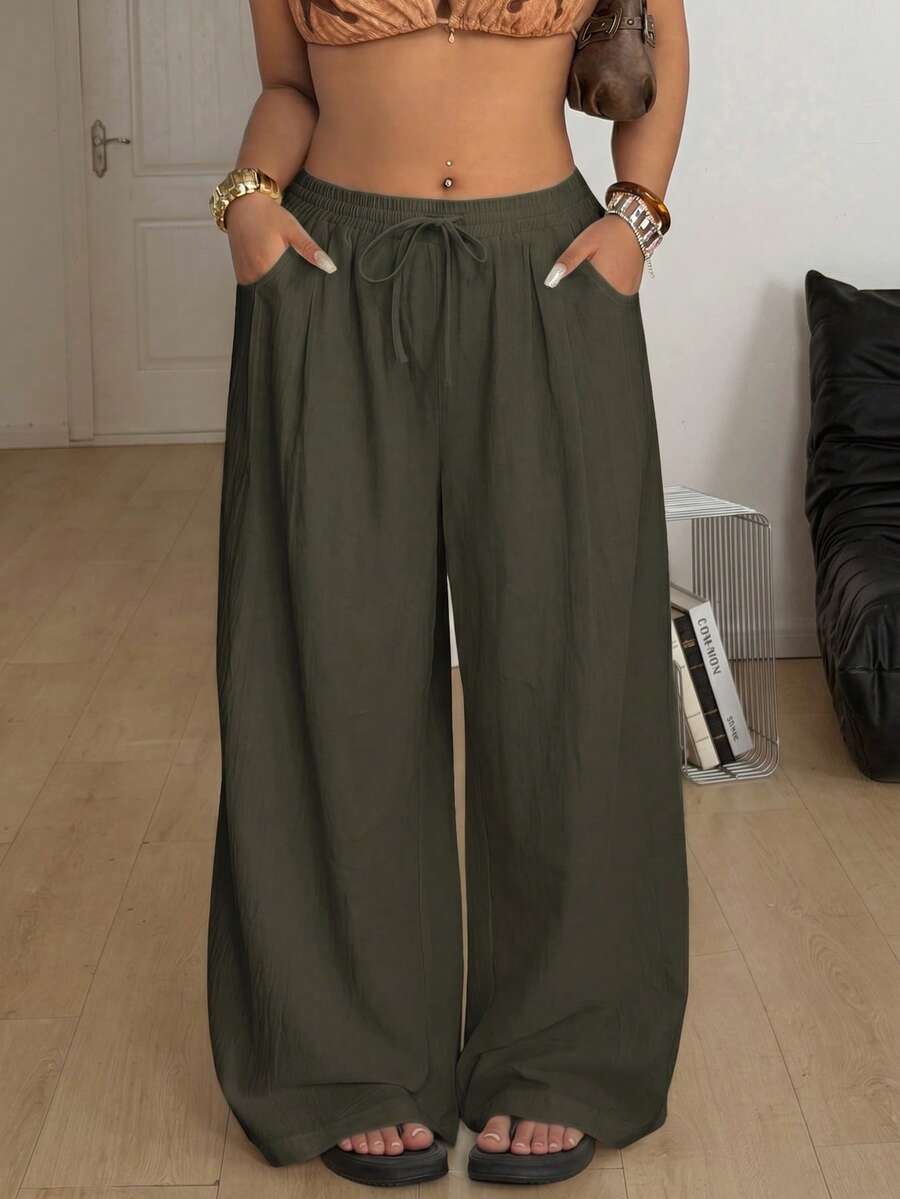 Women's loose straight leg cotton pants featuring a high waist with an adjustable drawstring knot and functional side pockets.