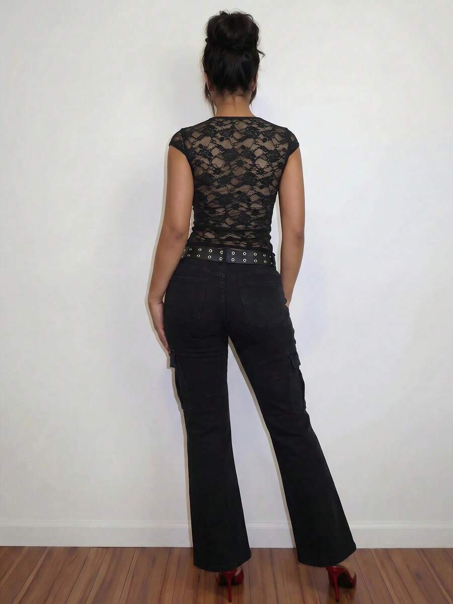 Women's black slim fit semi-sheer blouse featuring contrast lace detailing, a deep V hollow design with ring accent, asymmetrical hem, and cap sleeves.