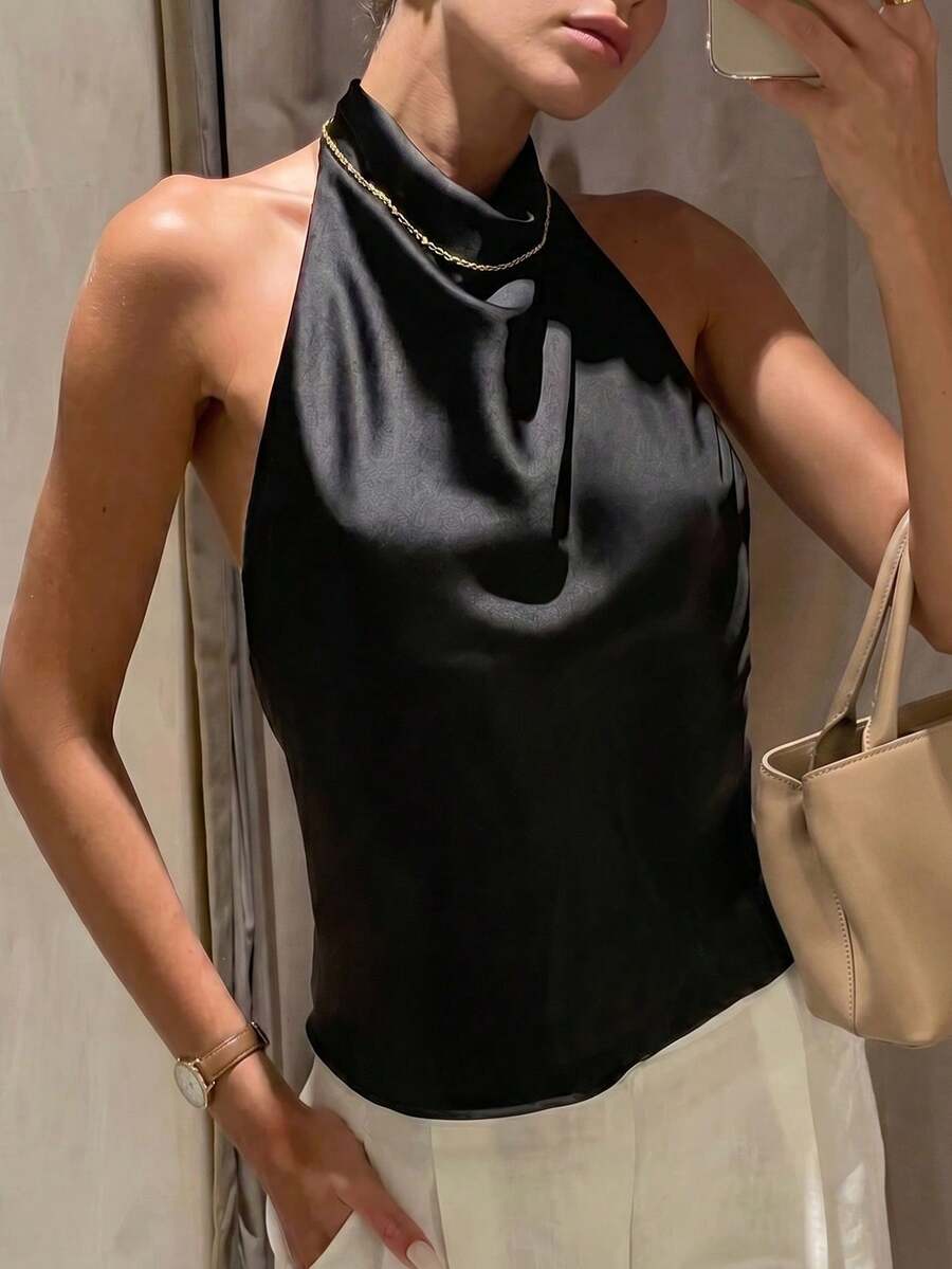 Women's black sleeveless halter top featuring a backless design and plain knitted fabric.