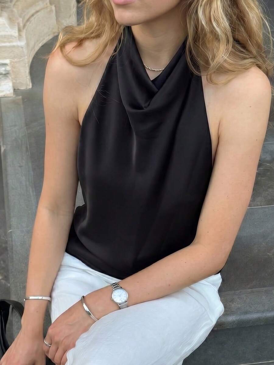 Women's black sleeveless halter top featuring a backless design and plain knitted fabric.