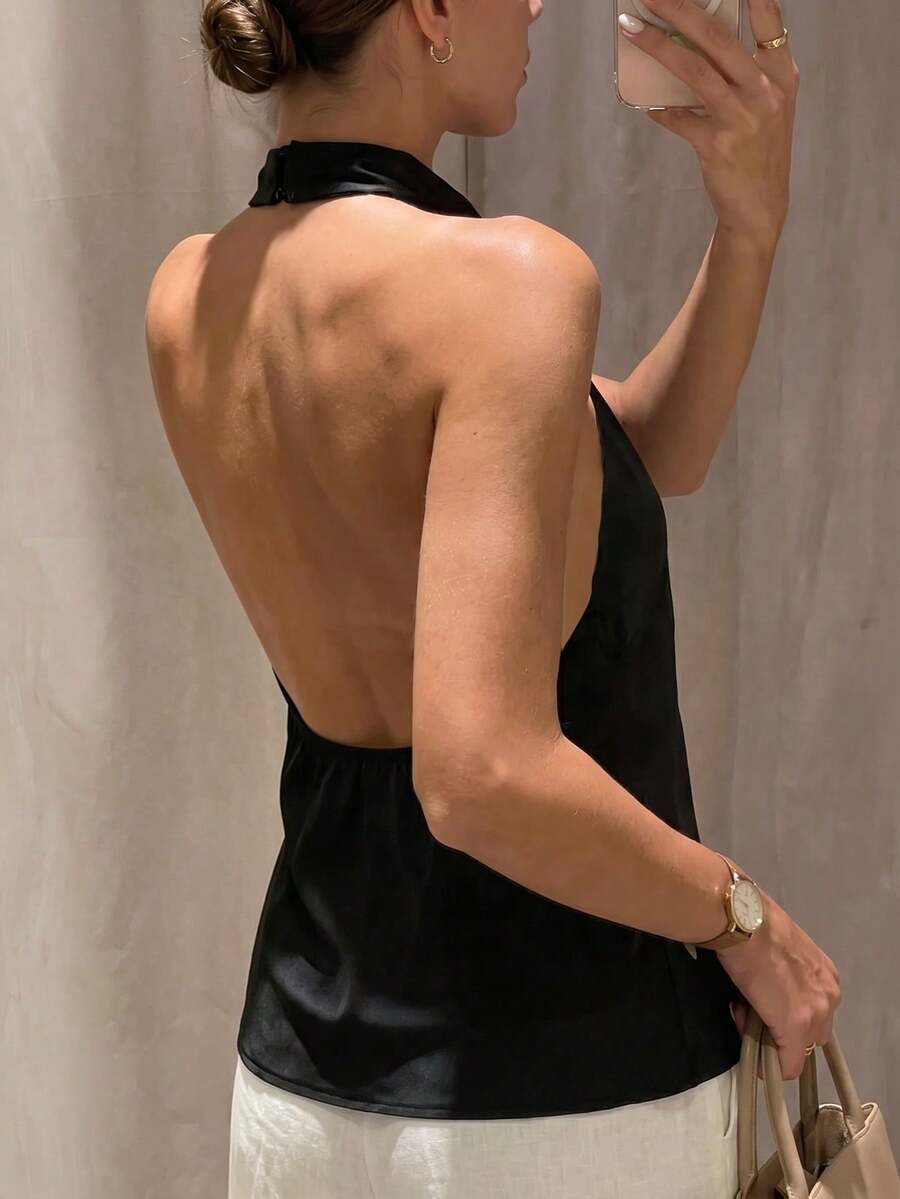 Women's black sleeveless halter top featuring a backless design and plain knitted fabric.