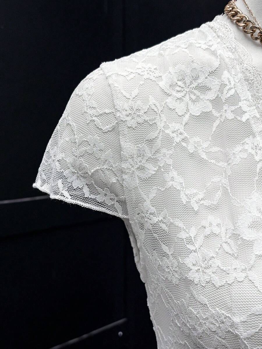 Women's semi-sheer deep V-neck top featuring cap sleeves, contrast lace trimming, and a lace-up front detail.