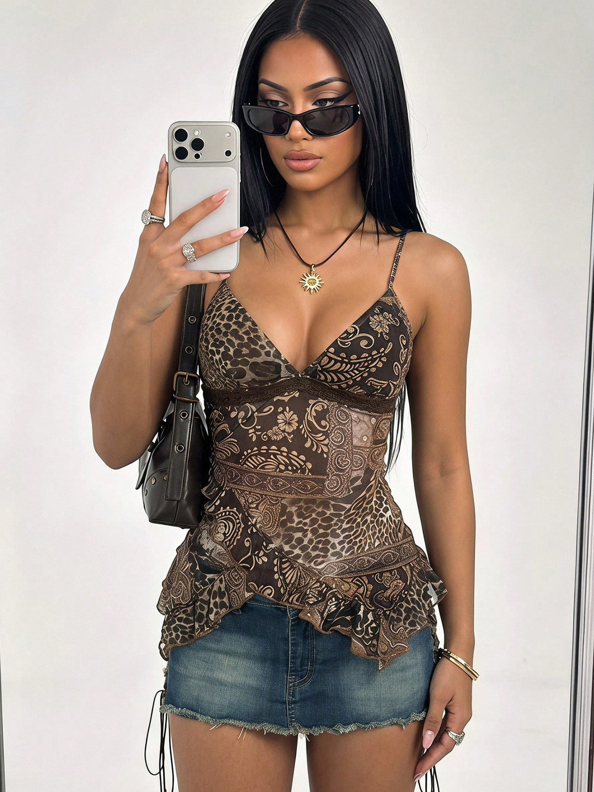 Women's graphic print camisole top featuring thin spaghetti straps, a backless cut, and an asymmetrical hem.
